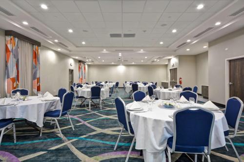 a conference room with tables and blue chairs at Hilton Garden Inn Tulsa-Broken Arrow, OK in Broken Arrow