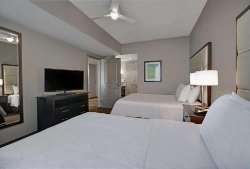 a hotel room with two beds and a flat screen tv at Homewood Suites by Hilton Hamilton, NJ in Hamilton