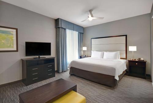 a hotel room with a bed and a flat screen tv at Homewood Suites by Hilton Hamilton, NJ in Hamilton