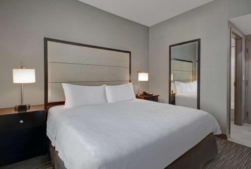 a large white bed in a hotel room with two lamps at Homewood Suites by Hilton Hamilton, NJ in Hamilton