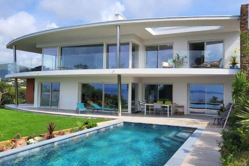 une maison avec une piscine devant dans l'établissement Magnificent panoramic sea view!, à Saint-Peïre-sur-Mer