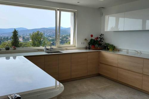 une cuisine avec un évier et une grande fenêtre dans l'établissement Magnificent panoramic sea view!, à Saint-Peïre-sur-Mer