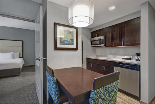 a kitchen with a table and a room with a bed at Homewood Suites by Hilton Hamilton, NJ in Hamilton