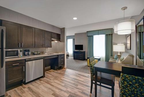 a kitchen with a dining table and a living room at Homewood Suites by Hilton Hamilton, NJ in Hamilton