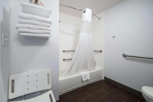 a bathroom with a shower and a toilet and towels at Hampton Inn Tulsa/Broken Arrow in Broken Arrow