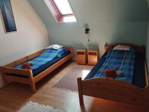a bedroom with two twin beds and a window at Liget Szálláshely in Berettyóújfalu