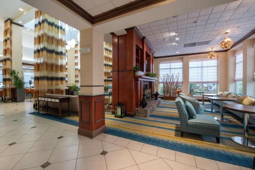 a lobby of a hospital with tables and chairs at Hilton Garden Inn Tupelo in Tupelo
