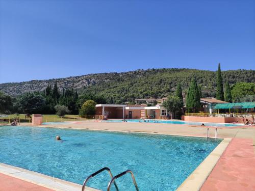 une grande piscine avec une montagne en arrière-plan dans l'établissement Le Romarin, à Beaumes-de-Venise