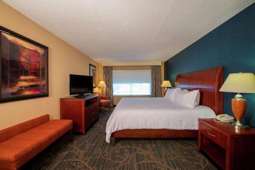 una camera d'albergo con letto e TV di Hilton Garden Inn Tupelo a Tupelo
