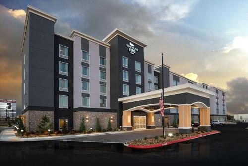 a hotel building with a flag in front of it at Homewood Suites By Hilton Tulsa Catoosa in Catoosa