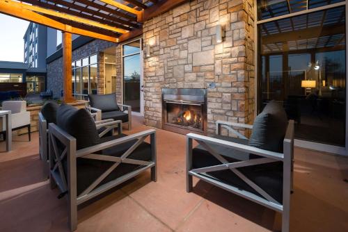 a patio with two chairs and a fireplace at Homewood Suites By Hilton Tulsa Catoosa in Catoosa