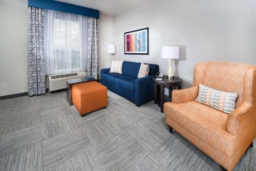 a living room with a couch and a chair at Homewood Suites By Hilton Tulsa Catoosa in Catoosa