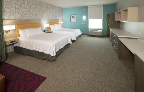 a hotel room with two beds and a kitchen at Home2 Suites by Hilton Owasso in Owasso