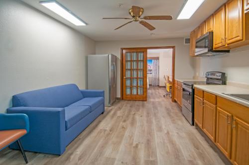 a living room with a blue couch in a kitchen at Days Inn & Suites by Wyndham San Antonio North/Stone Oak in San Antonio