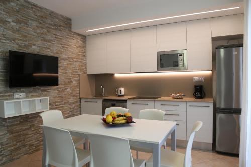 a kitchen with a table with a bowl of fruit on it at Villaggio Mare Blu in Bibione