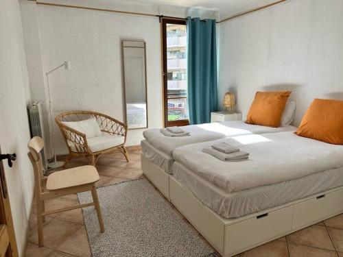 une chambre avec un lit, une chaise et une fenêtre dans l'établissement Résidence MANDARINIERS Cannes, à Cannes