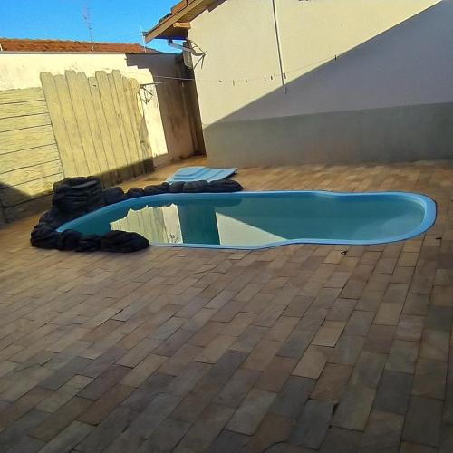 un skateboard posé sur le sol à côté d'une piscine dans l'établissement Casa em Olímpia - Recanto Gonçalves, à Olímpia