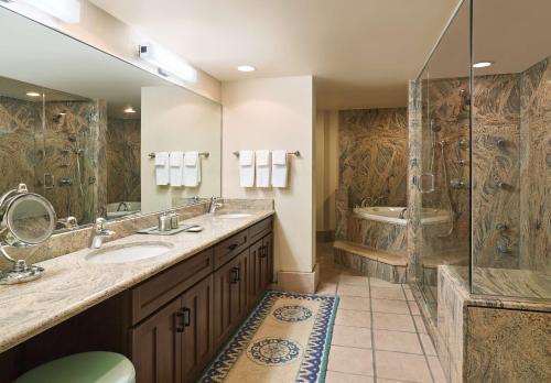 a bathroom with two sinks and a shower at El Conquistador Tucson, A Hilton Resort in Tucson