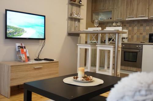 a living room with a table and a tv at Apartman_Krstić_1 in Subotica