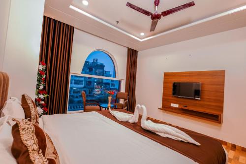 sypialnia z łóżkiem z telewizorem i oknem w obiekcie Hotel Lalita Palace w mieście Dżajpur