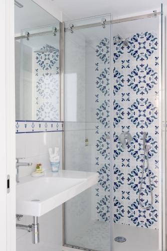 y baño blanco con lavabo y ducha. en Residenza Amalphia, en Amalfi