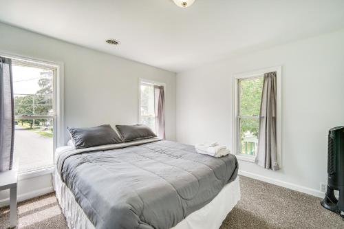 a white bedroom with a bed and two windows at Cozy Glens Falls Getaway Less Than 1 Mi to Downtown in Glens Falls