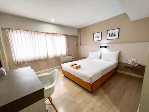 ein Hotelzimmer mit einem Bett, einem Tisch und Stühlen in der Unterkunft Srivichai Hotel in Nakhon Ratchasima