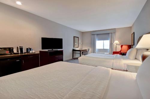 a hotel room with two beds and a flat screen tv at Hilton Garden Inn Twin Falls in Twin Falls