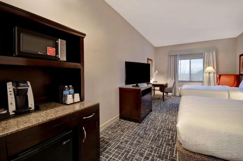 a hotel room with a bed and a flat screen tv at Hilton Garden Inn Twin Falls in Twin Falls