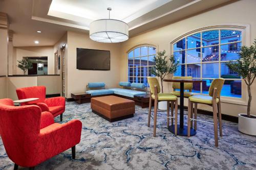 a living room with red chairs and a table at Hilton Garden Inn Valencia Six Flags in Valencia