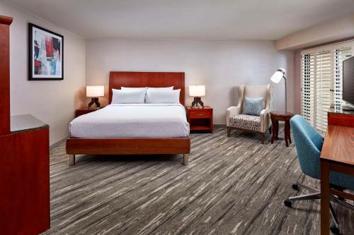 - une chambre avec un lit, un bureau et une chaise dans l'établissement Hilton Garden Inn Valencia Six Flags, à Valencia
