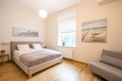 a bedroom with a bed and a couch and a window at Lossi 32 Cozy Apartment in Tartu