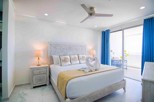 um quarto branco com uma cama grande e uma ventoinha de tecto em Casa Blanca Golf Villas em Puerto Peñasco