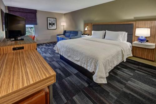 a hotel room with a bed and a flat screen tv at Hampton Inn Dumfries/Quantico in Dumfries