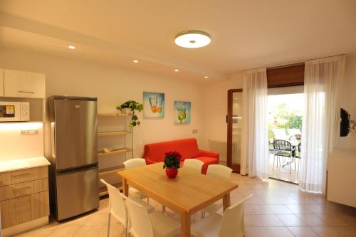 a kitchen and dining room with a table and a refrigerator at Villaggio Mare Blu in Bibione