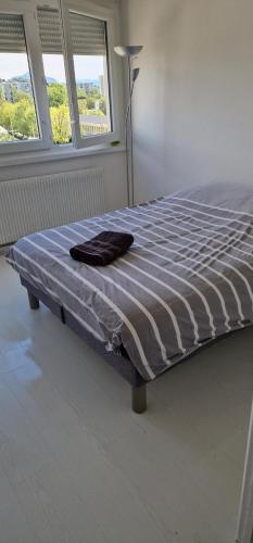 - un lit dans une chambre avec une couverture dans l'établissement T3 Annemasse 4eme étage Proche Genève, à Annemasse