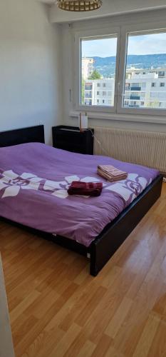 um quarto com uma cama roxa com duas toalhas em T3 Annemasse 4eme étage Proche Genève em Annemasse