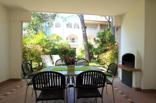 a dining room table with chairs and a fireplace at Villaggio Mare Blu in Bibione