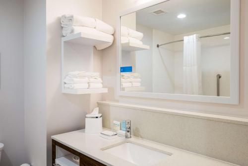 bagno con lavandino, specchio e asciugamani di Hampton Inn Newport a Newport