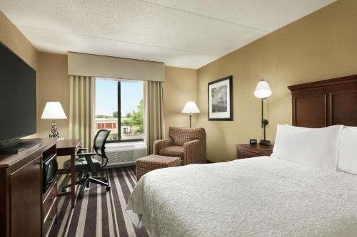 a hotel room with a bed and a desk and a chair at Hampton Inn Washington-Dulles International Airport South in Chantilly