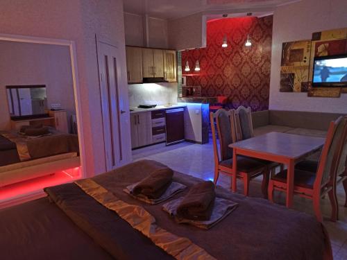 オデッサにあるApartHotel Domのベッド1台付きの部屋、テーブル付きのキッチンが備わる客室です。