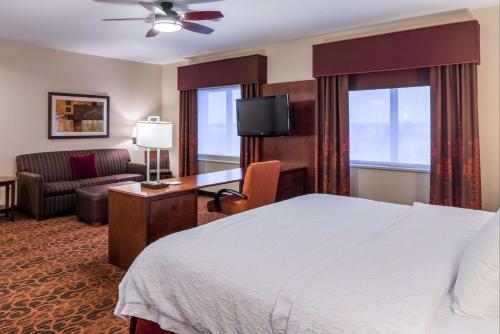 a hotel room with a bed and a couch at Hampton Inn & Suites Boulder North in Boulder