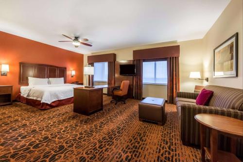 a hotel room with a bed and a couch at Hampton Inn & Suites Boulder North in Boulder