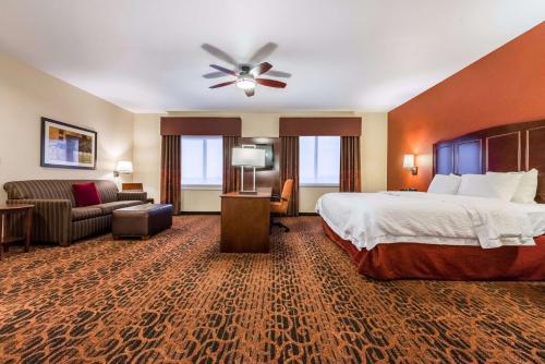 a hotel room with a bed and a couch at Hampton Inn & Suites Boulder North in Boulder