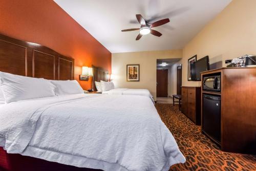 a hotel room with a large bed and a ceiling fan at Hampton Inn & Suites Boulder North in Boulder