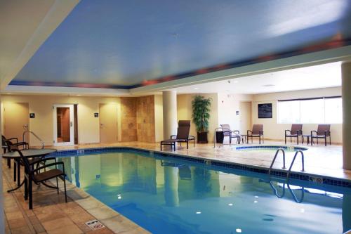 una piscina en un hotel con sillas y mesas en Hampton Inn & Suites Wells-Ogunquit, en Wells