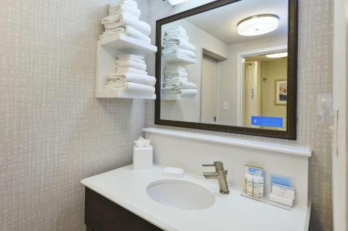 a bathroom with a sink and a mirror and towels at Hampton Inn & Suites Wells-Ogunquit in Wells