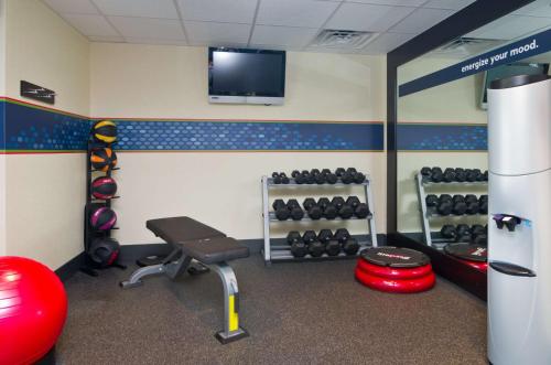 a gym with a bench and a tv in a room at Hampton Inn Wooster in Wooster