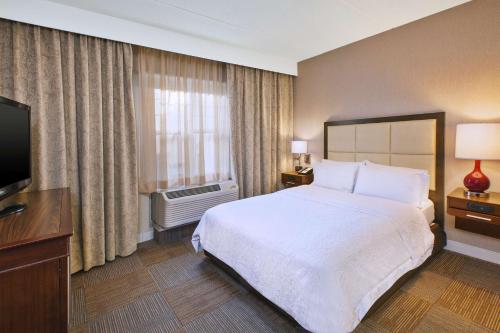 a hotel room with a bed and a television at Hampton Inn & Suites Providence-Warwick Airport in Warwick