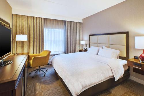 a hotel room with a large bed and a desk at Hampton Inn & Suites Providence-Warwick Airport in Warwick